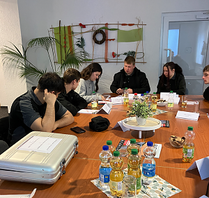 Azubis arbeiten gemeinsam am Tisch an der L&ouml;sung der R&auml;tsel