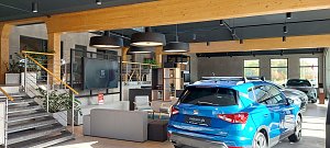 Innebereich des Autohauses mit Sitzecke für die Wartekunden und einem ausgestellten blauen Seat