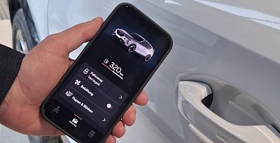 Eine Hand h&auml;lt ein Smartphone vor einem Auto. Auf dem Smartphone sind Inhalte der Connect App abgebildet, zum Beispiel aktuelle Tankf&uuml;llung. (Ratio Mobil)